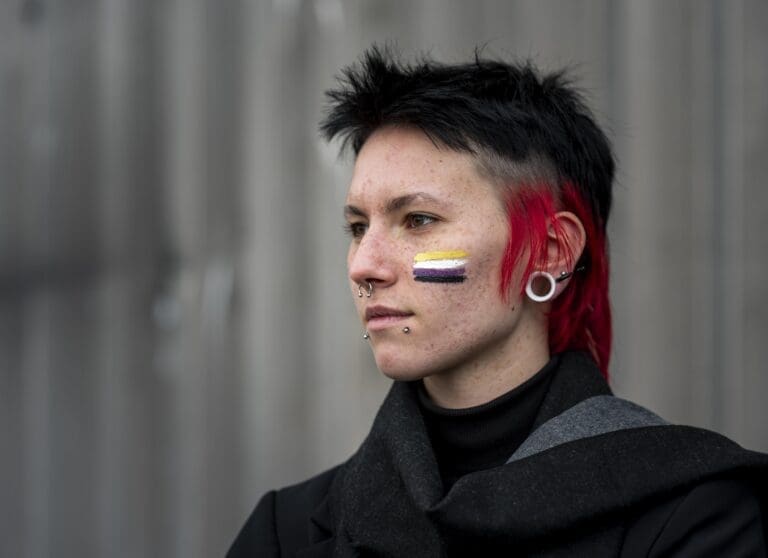 side view person having non binary flag painted cheek